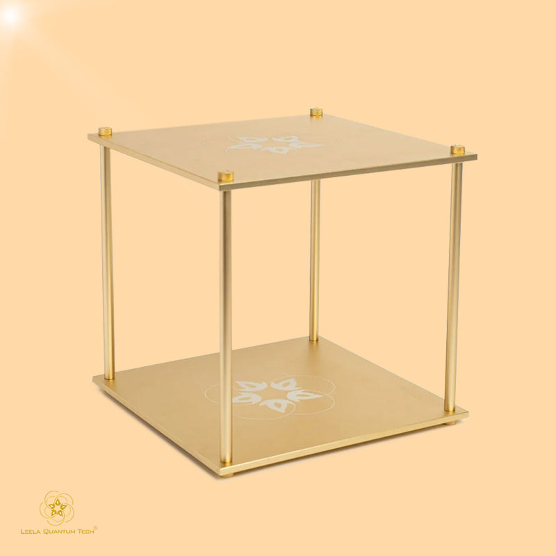 A gold-colored cube-shaped device with a geometric design on the upper surface, possibly a frequency block device used for harmonizing EMF radiation.
