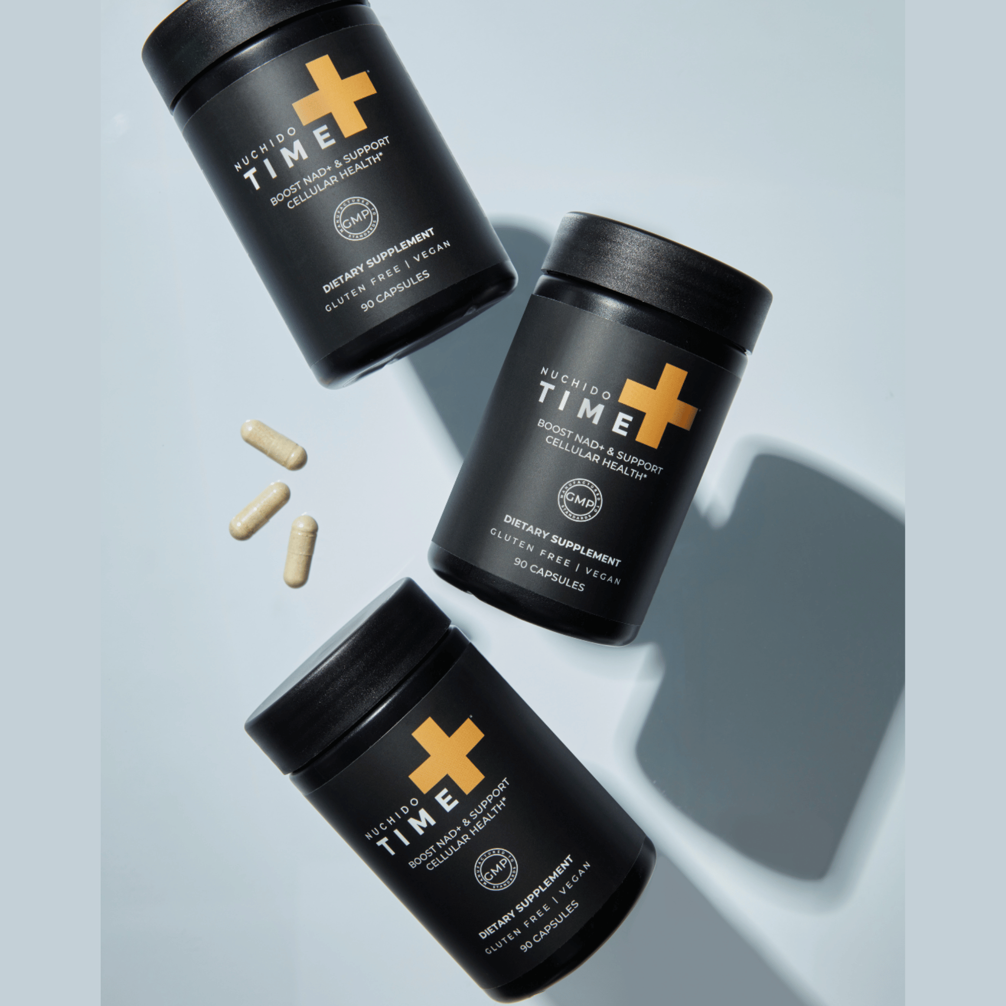 Three black supplement containers with a plus sign on a light blue background